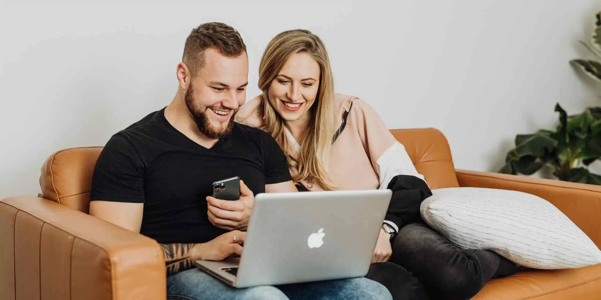 Couple on sofa with laptop attending Exploring Fostering virtual event