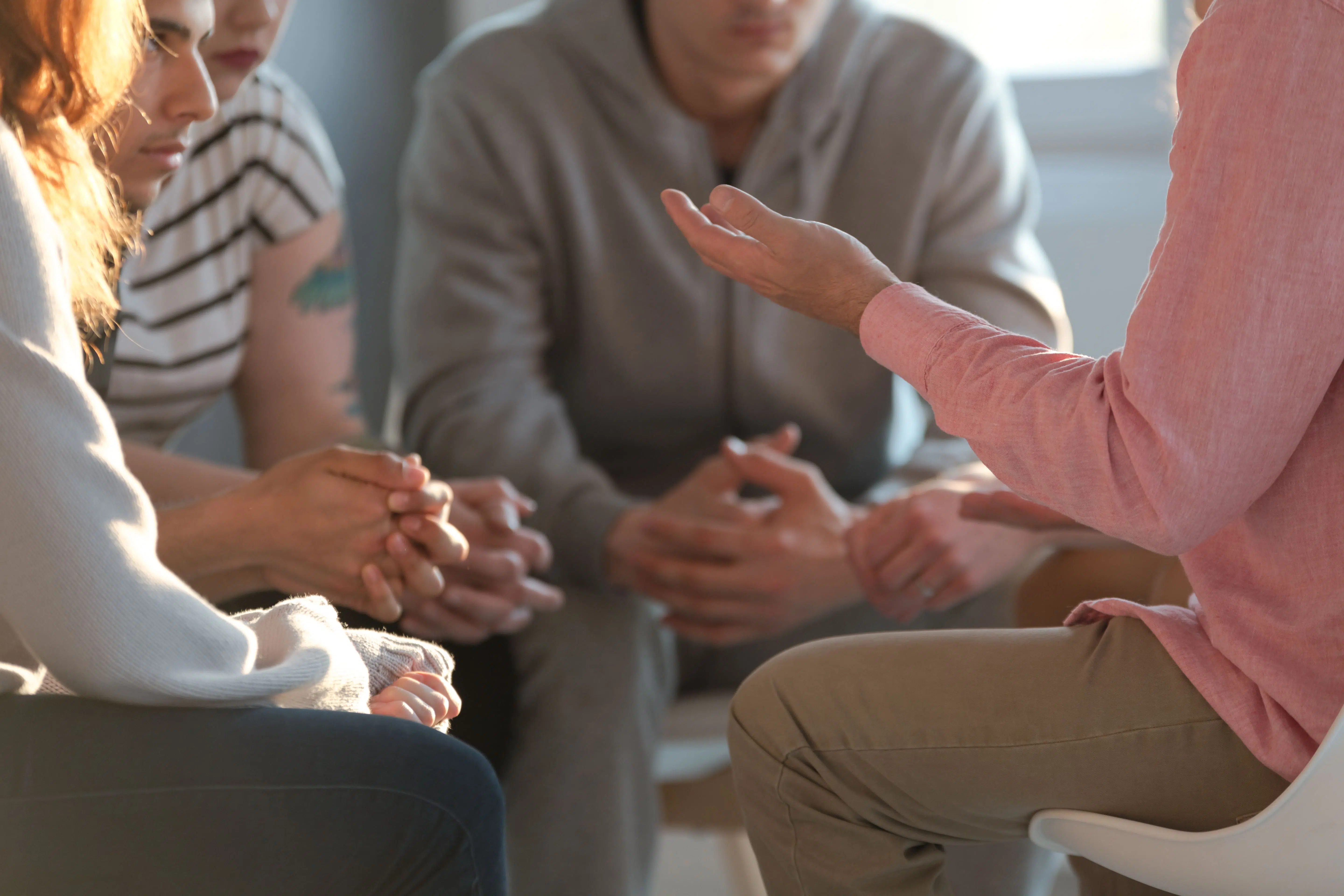 Close up of group having a conversation with focus on the hands to represent reflective groups for foster carers