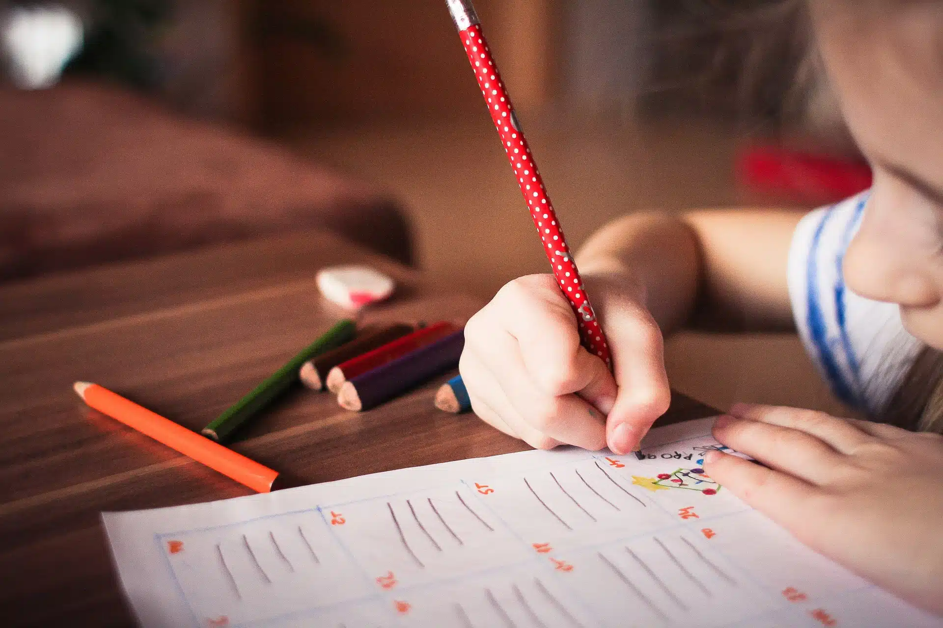 A young child writing in a book.