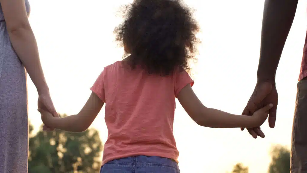 foster child holding hands with foster parents in worcestershire