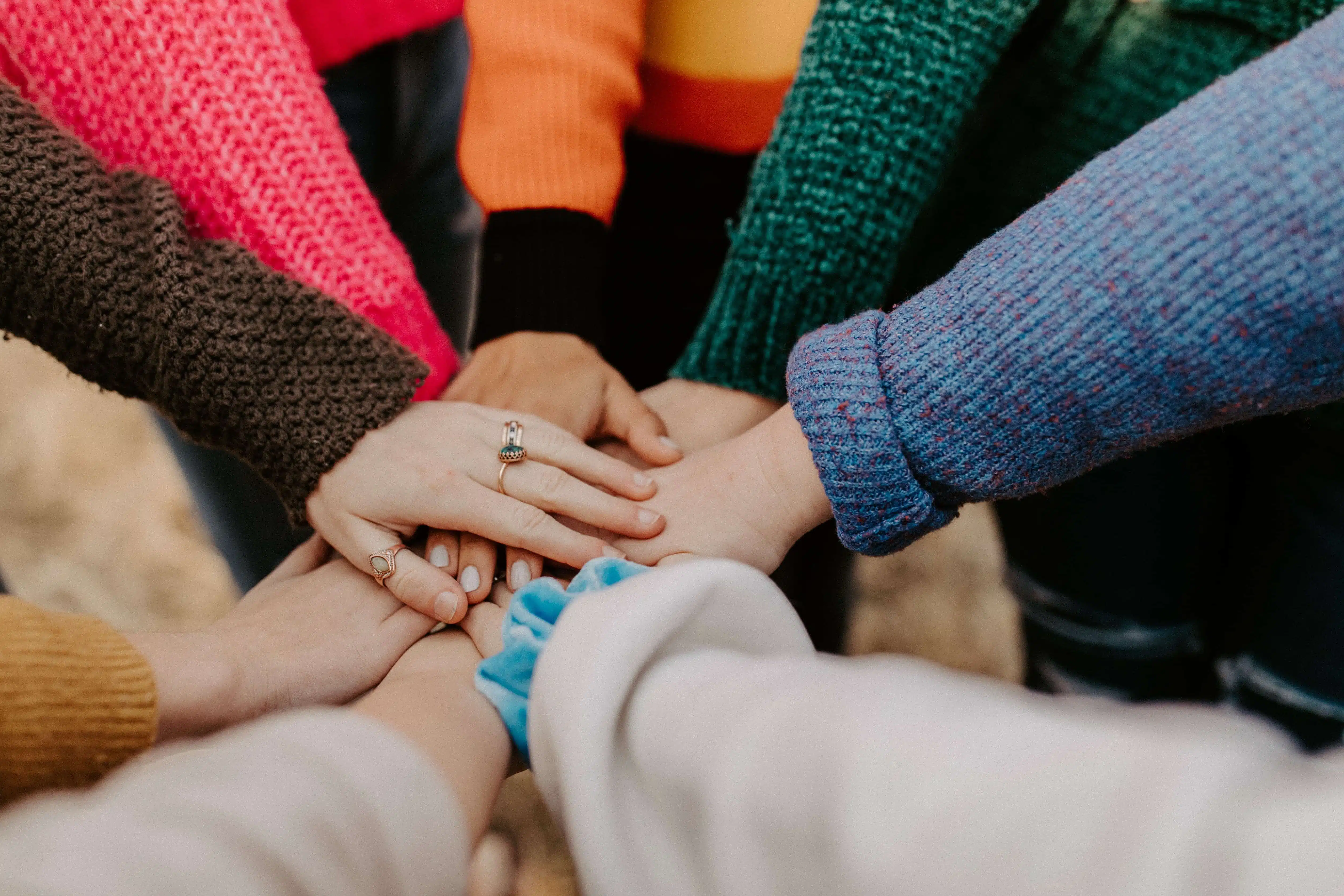 People putting their hands together in a circle.