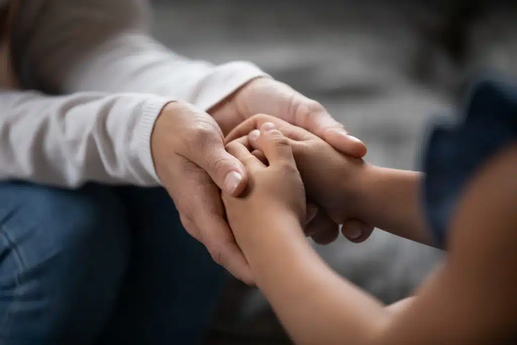 adult and small child holding hands